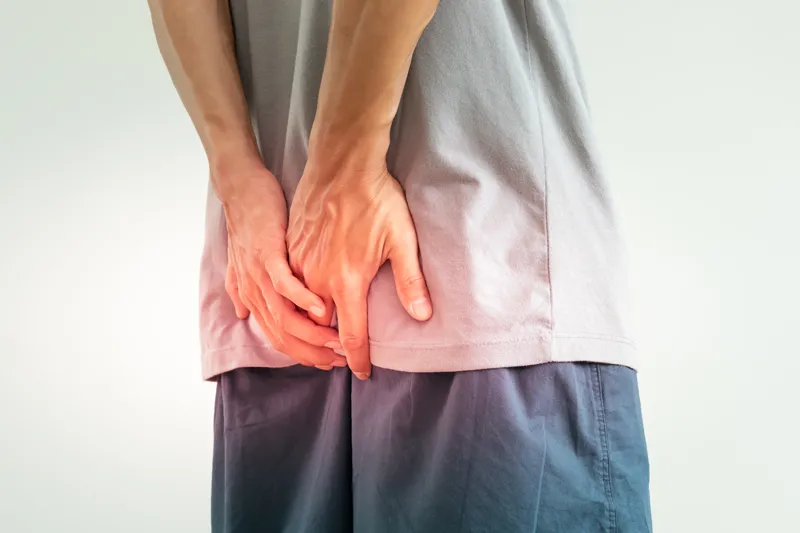 Man experiencing anal pain that may be caused by an anal abscess or haemorrhoids