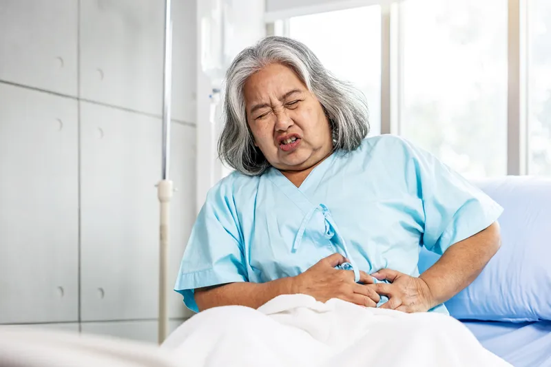 Older woman holding her abdomen due to abdominal pain