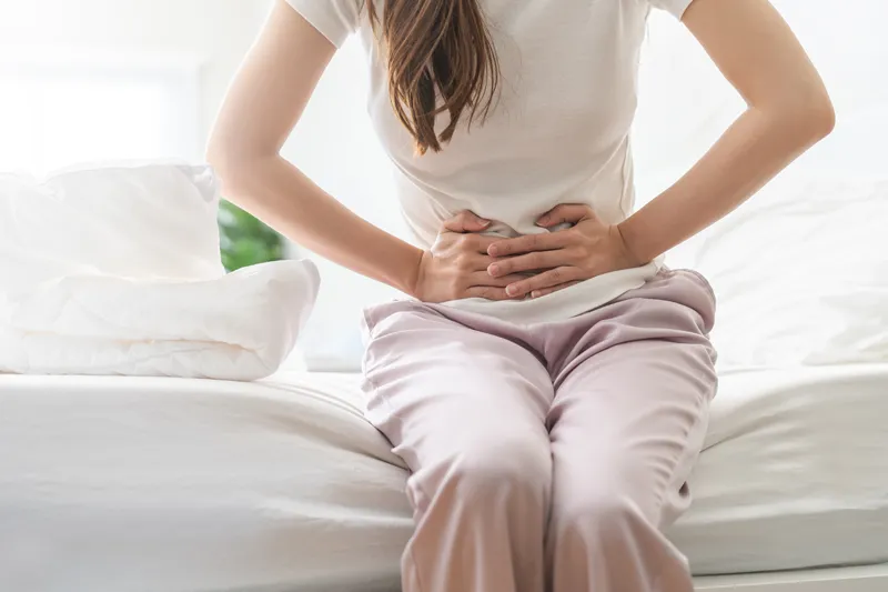 Woman with abdominal pain clutching her lower abdomen