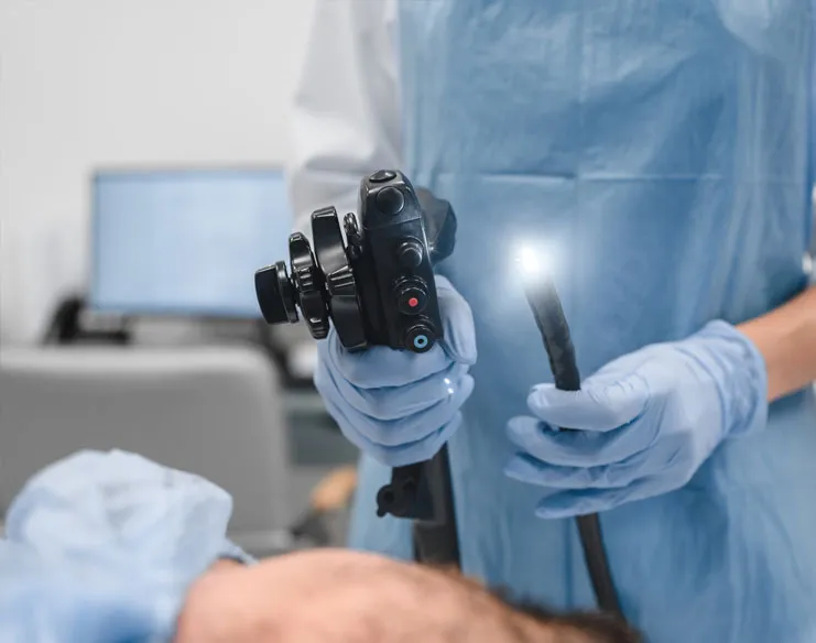 Colorectal cancer surgeon holding a flexible endoscope used for a colonoscopy procedure.