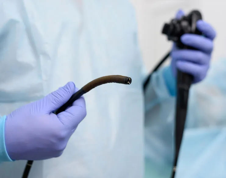 Colorectal cancer surgeon holding a flexible endoscope used for colonoscopy screening.