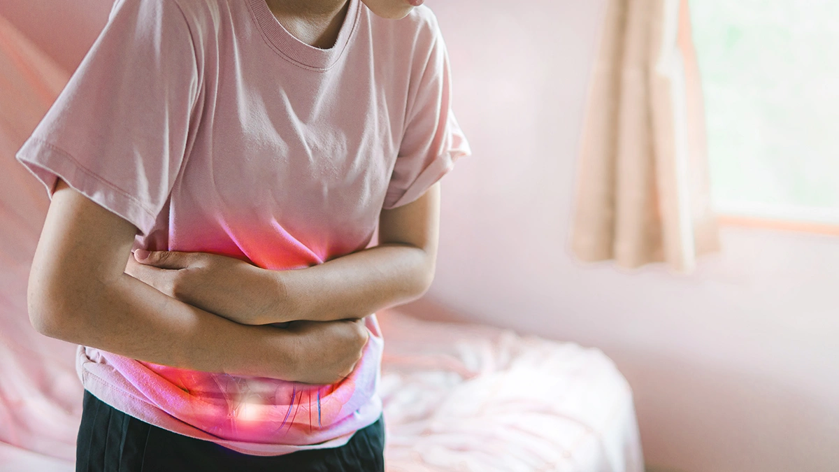 Woman experiencing abdominal bloating and discomfort while holding her stomach.