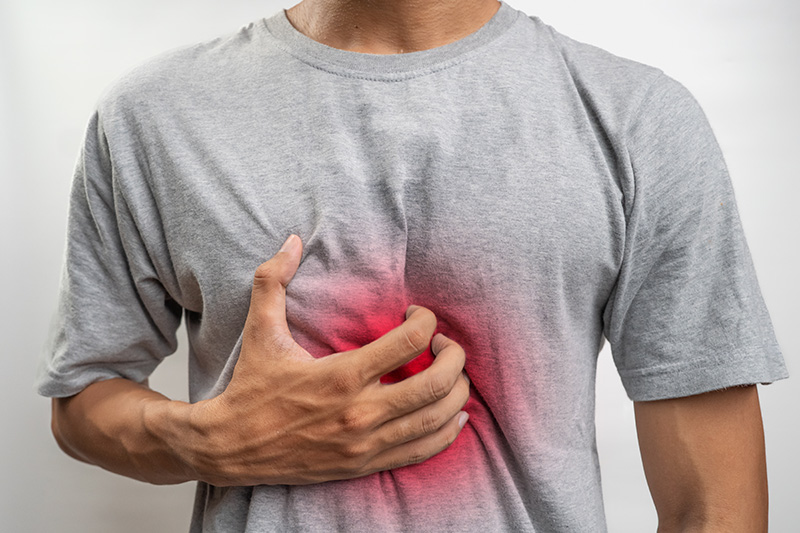 Man experiencing chest discomfort caused by heartburn.
