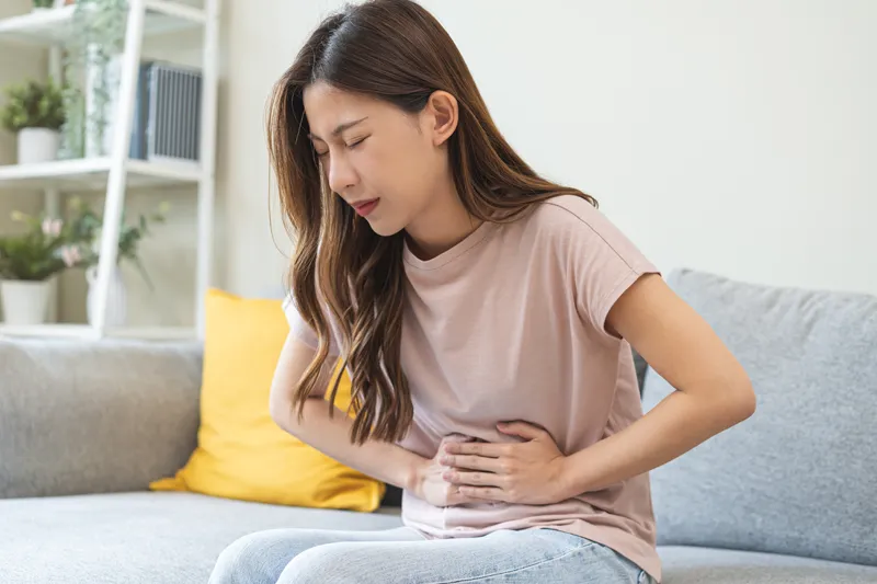 Woman experiencing abdominal pain associated with ulcerative colitis symptoms